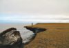 USGS researcher Benjamin Jones examines a collapsed block of ice-rich permafrost on Barter Island along Alaska's Arctic coast. Photo: Christopher Arp, USGS